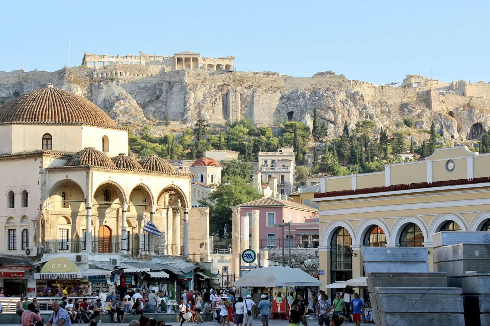 Animada plaza de Monastiraki con edificios históricos y animación callejera