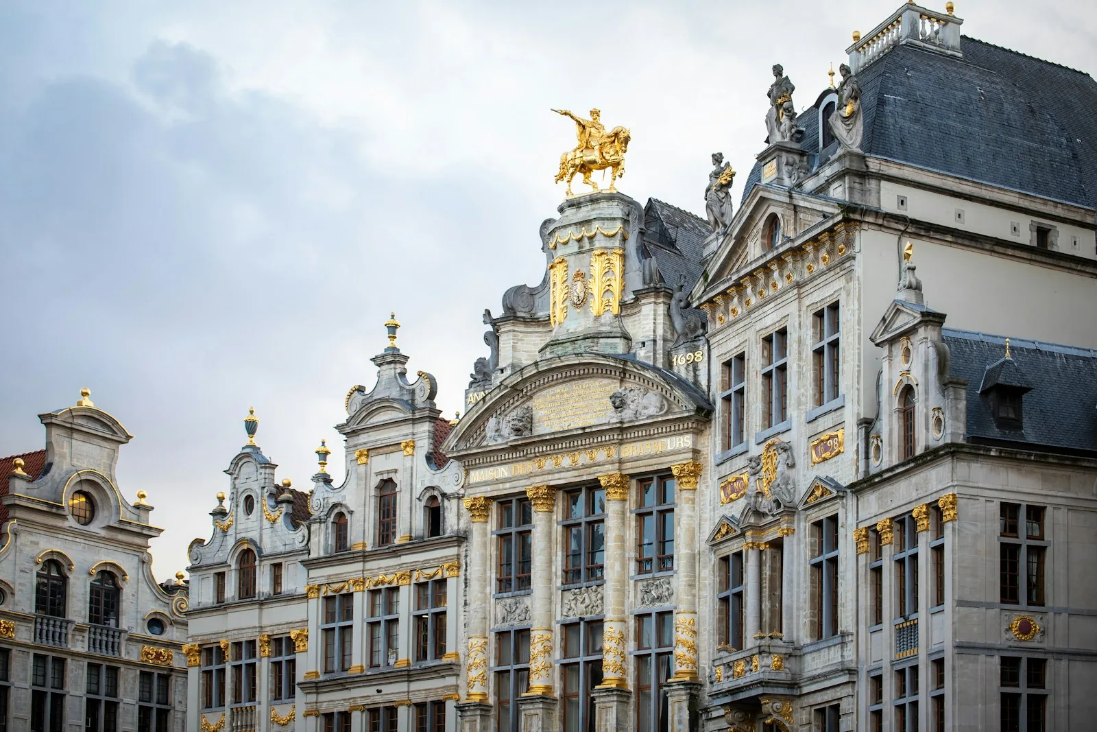 Fachadas doradas y torres gremiales de la Grand-Place bajo el cielo azul de Bruselas