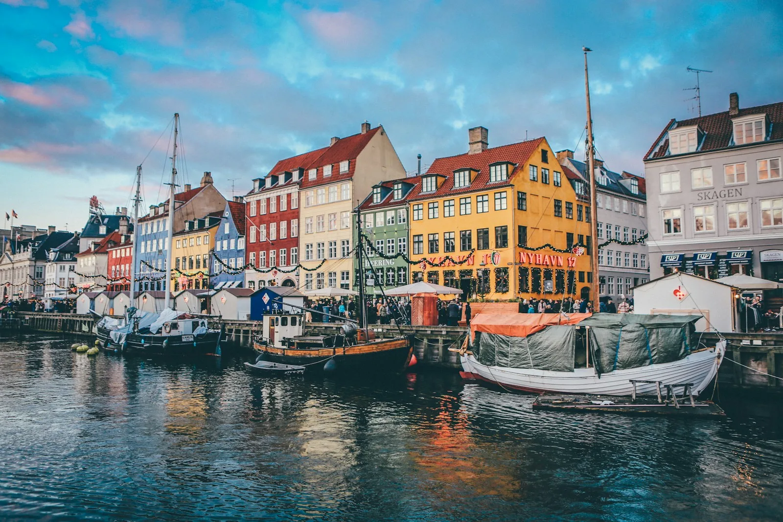 Casas señoriales de colores vivos y barcos de madera amarrados en el canal de Nyhavn en Copenhague