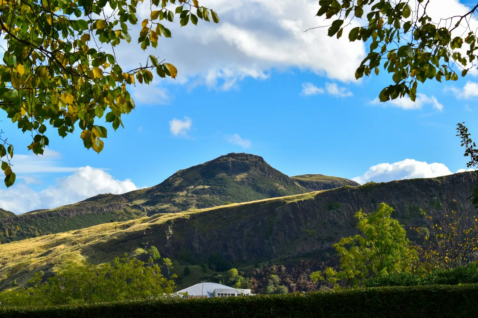 Colinas verdes y sendero hacia la cima de Arthur's Seat contemplando Edimburgo
