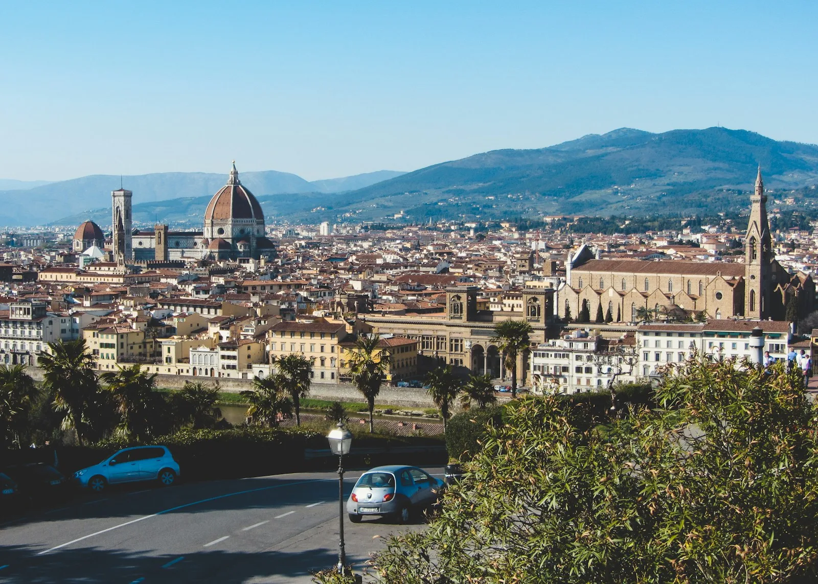 Panorámica de Florencia con la cúpula de Brunelleschi, el campanario de Giotto y los tejados toscanos con montañas al fondo
