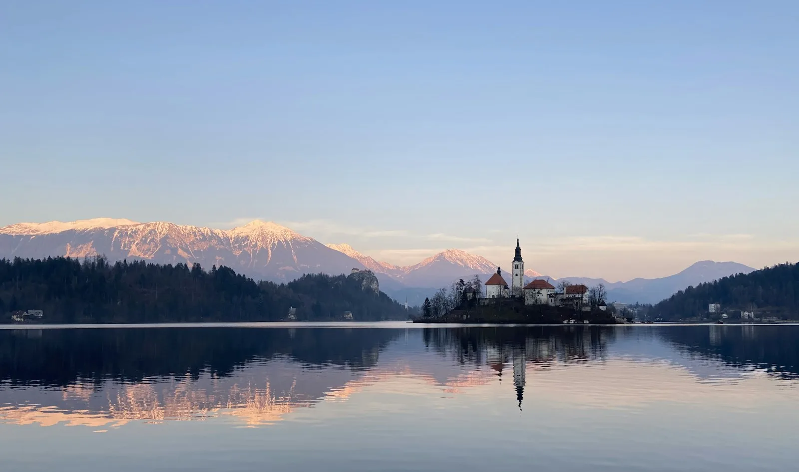 Isla del lago Bled con su iglesia barroca y las montañas nevadas de los Alpes Julianos al fondo