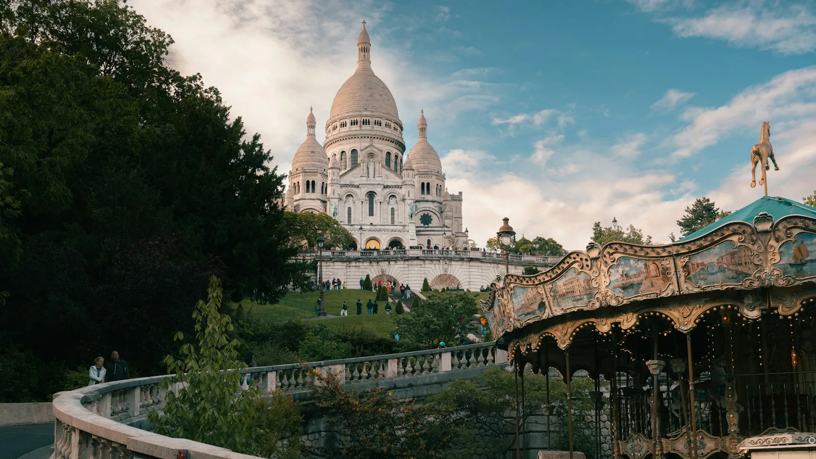Basílica del Sacré-Cœur dominando la colina de Montmartre con tiovivo tradicional