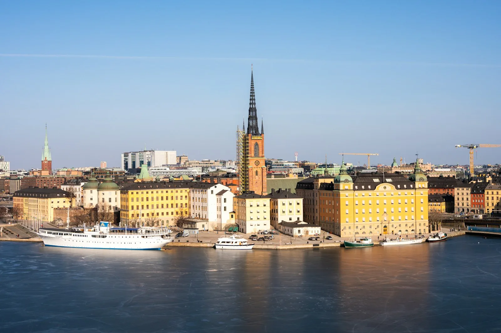 Panorámica de la isla de Riddarholmen y las agujas históricas de Estocolmo reflejadas en el agua al atardecer