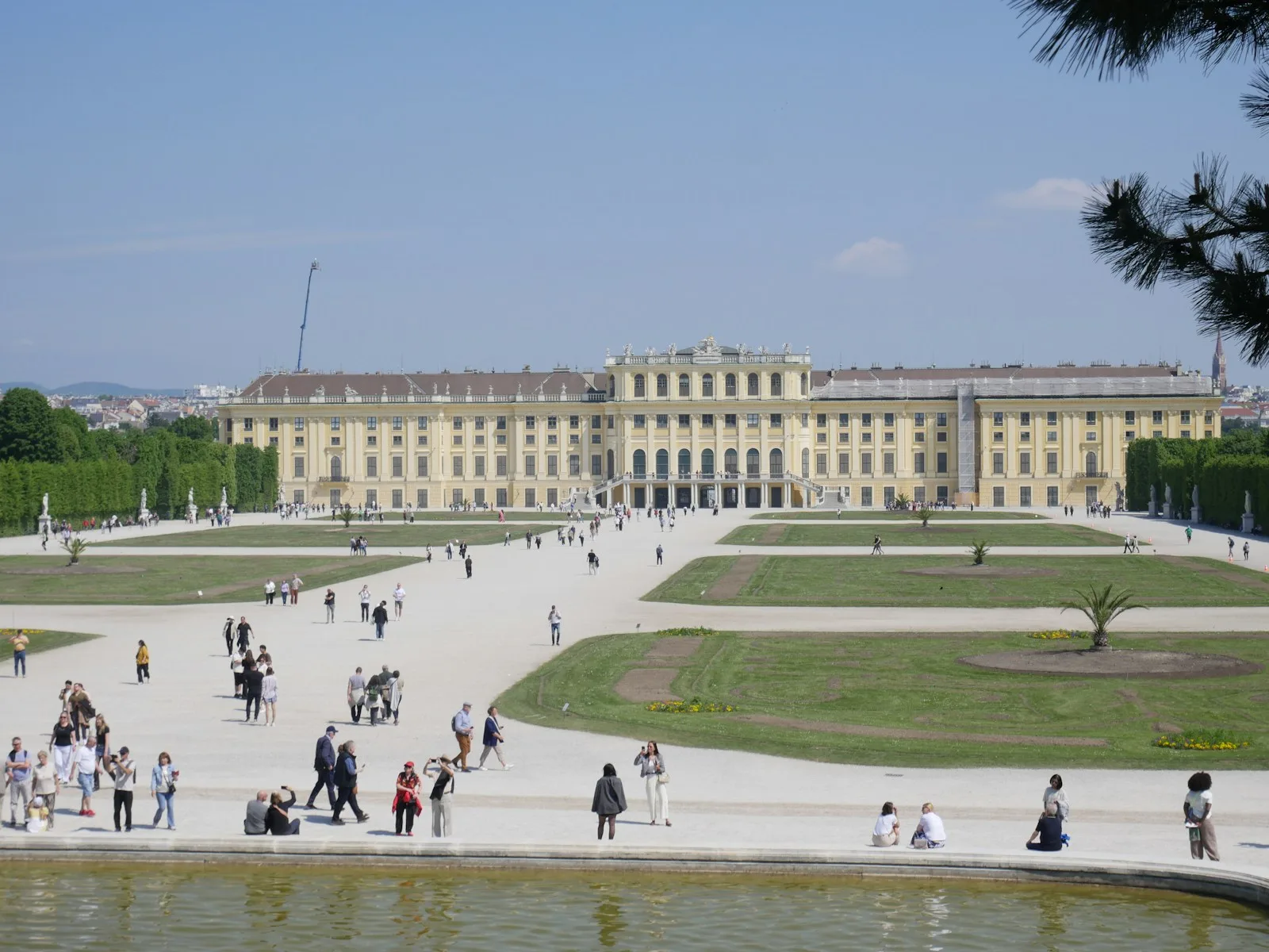 Paseantes en los jardines simétricos del Palacio de Schönbrunn en Viena